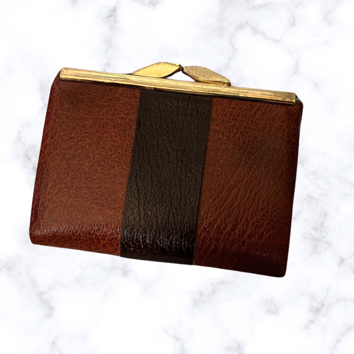Brown leather clutch with gold clasp on a white marble background
