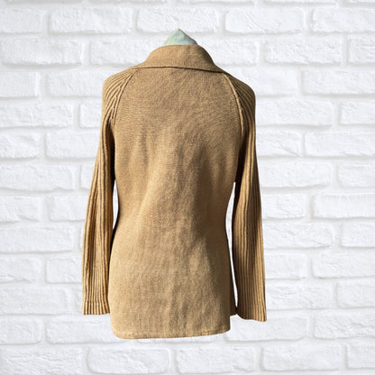 Beige knitted jacket on a mannequin against a white brick wall background