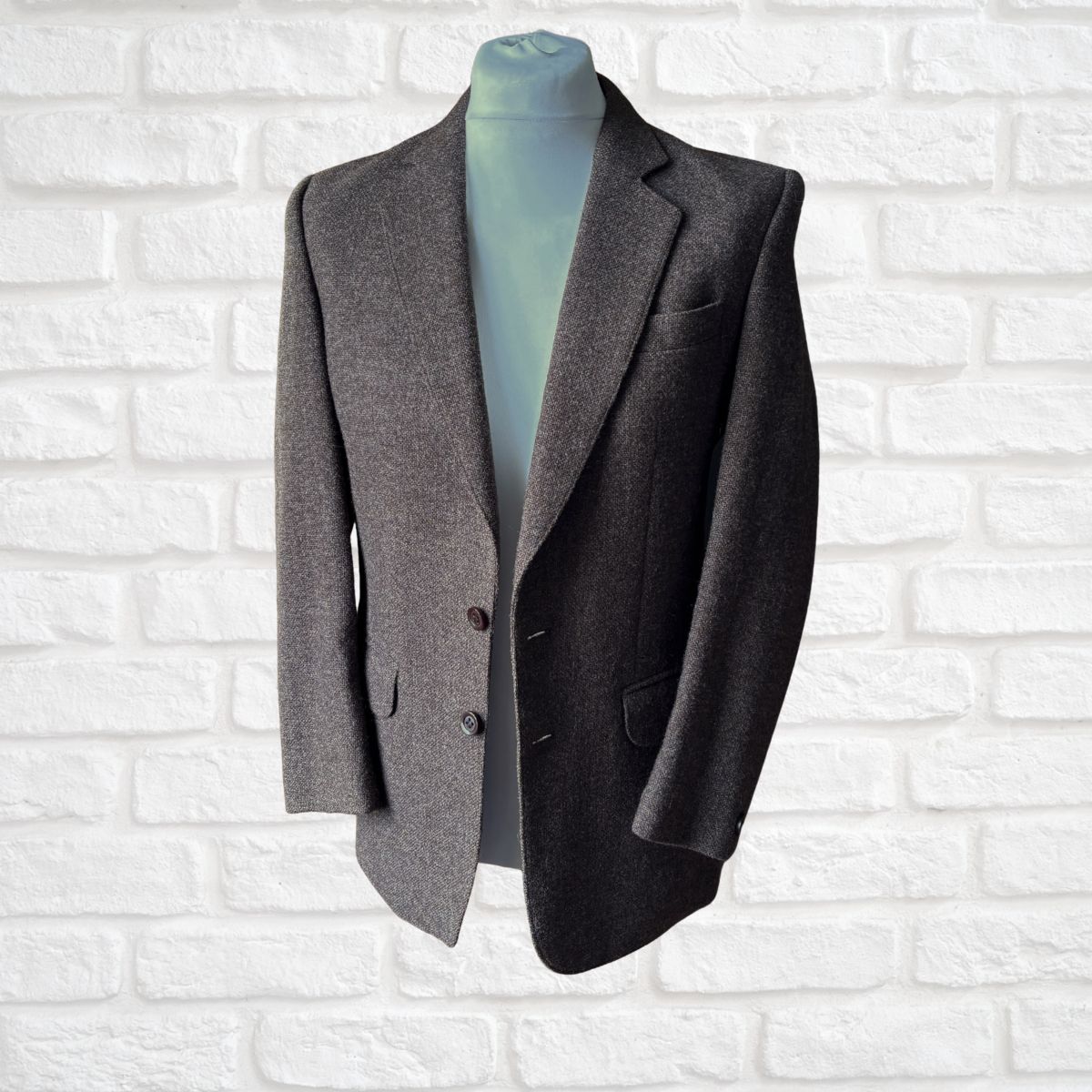 Brown  blazer on a mannequin against a white brick wall background