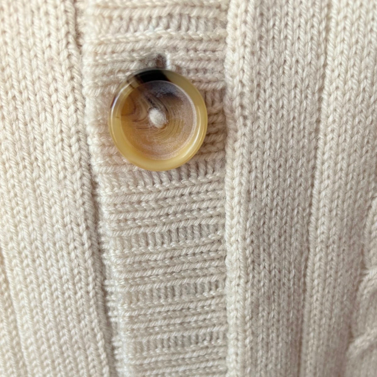 Close up of faux horn button on a vintage cardigan 