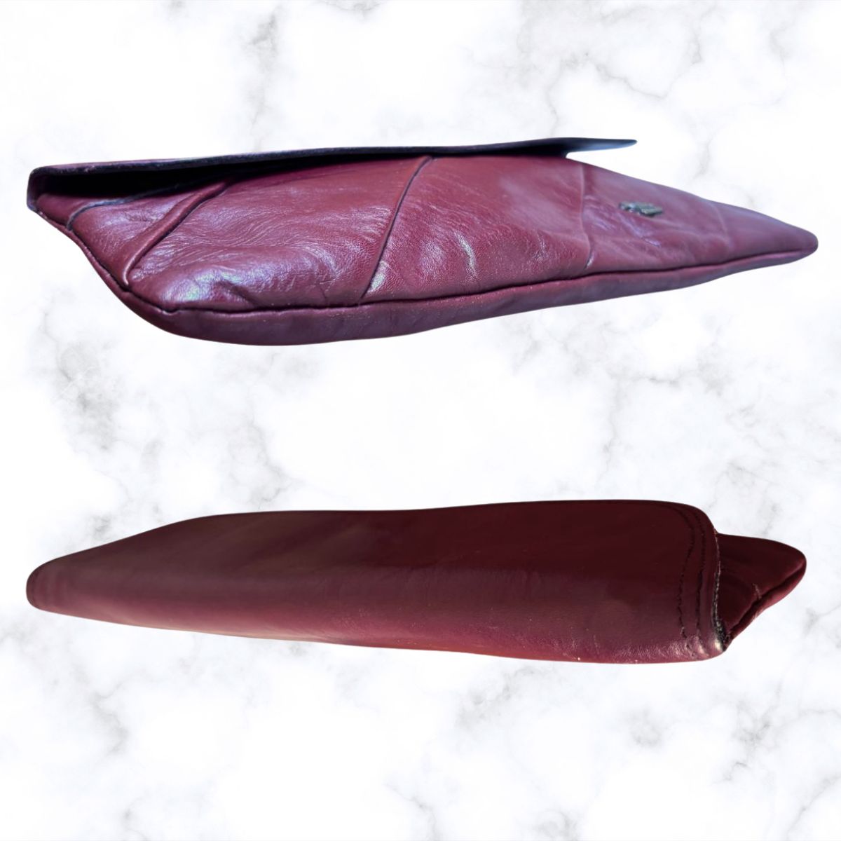 Two views of a maroon leather clutch bag on a white background