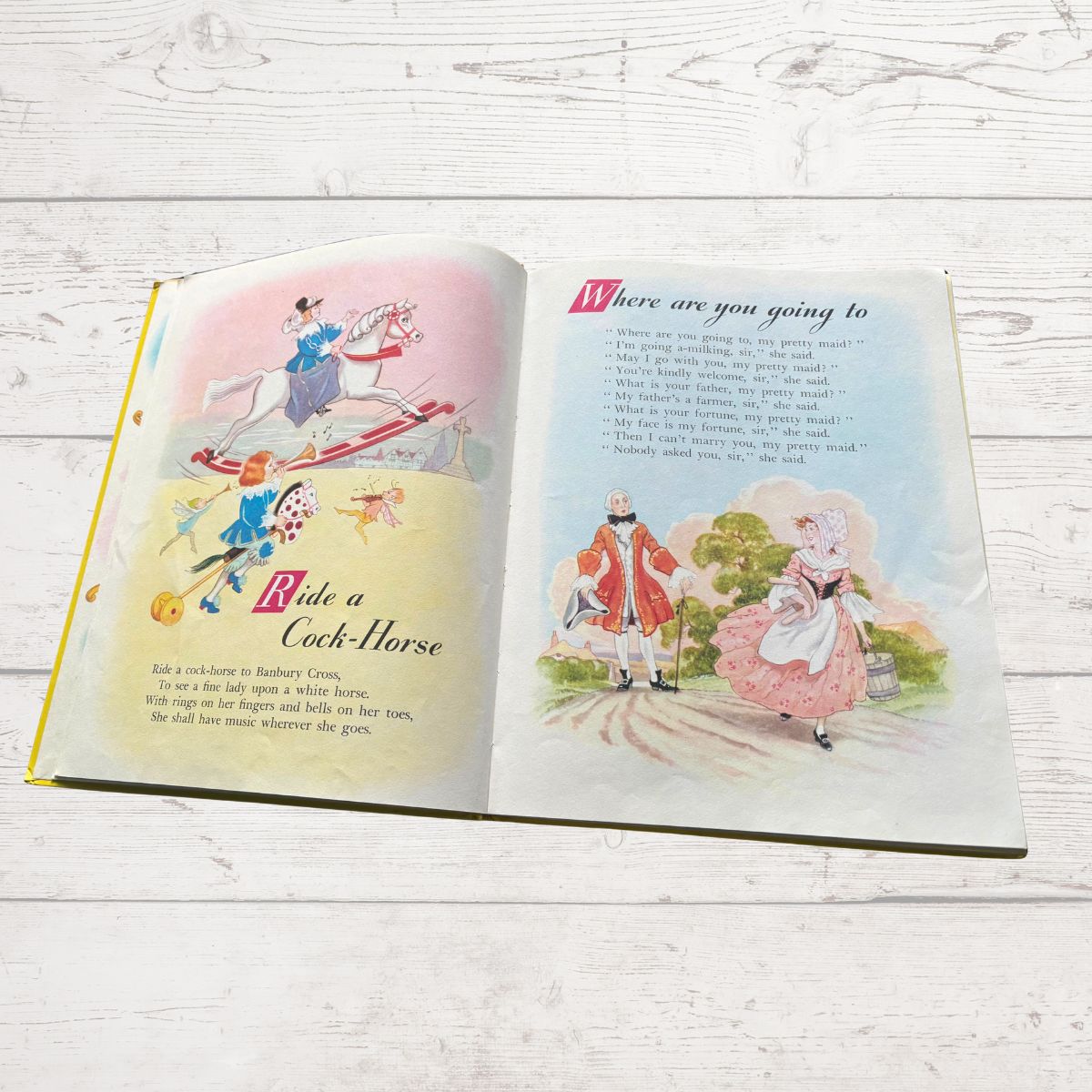 Open book with illustrations and text on a wooden surface