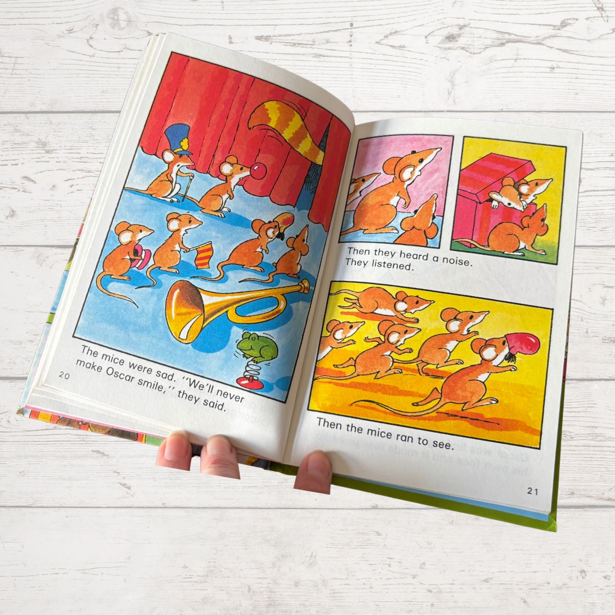 Open children's book with colorful illustrations of mice on a wooden surface