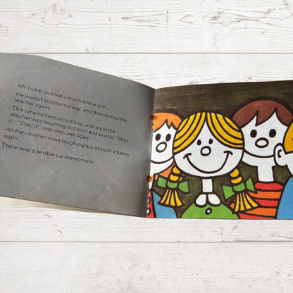 Open book with colorful illustration of children on a wooden surface