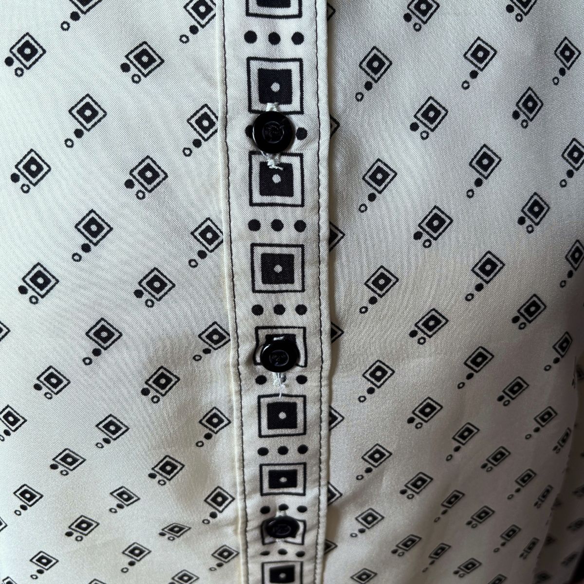 Cream and black geometric print 70s shirt front placket on a white background 