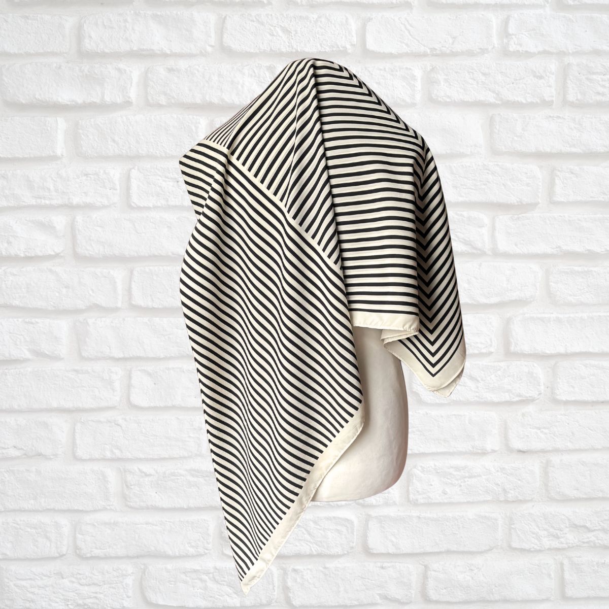 Cream and black striped vintage scarf on a white background 