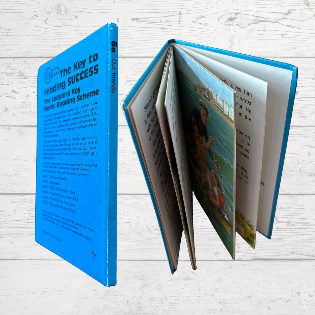 Open book with blue cover on a light wooden surface
