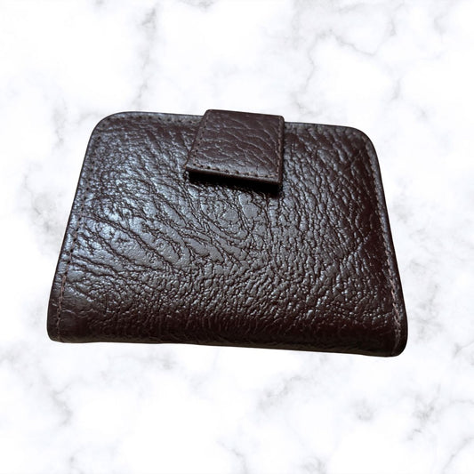 Brown leather wallet on a white marble surface