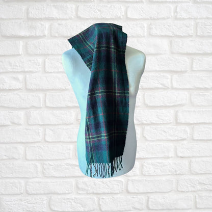 Plaid scarf on a mannequin against a white brick wall background