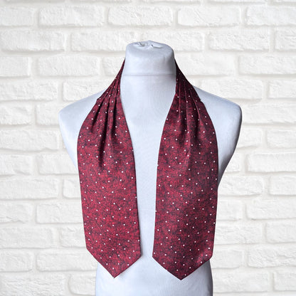 Red patterned cravat on a mannequin against a white brick wall background