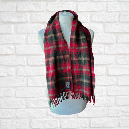 Plaid scarf on a mannequin against a white brick wall background