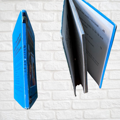 Blue book spine close up with a white interior on a white brick background