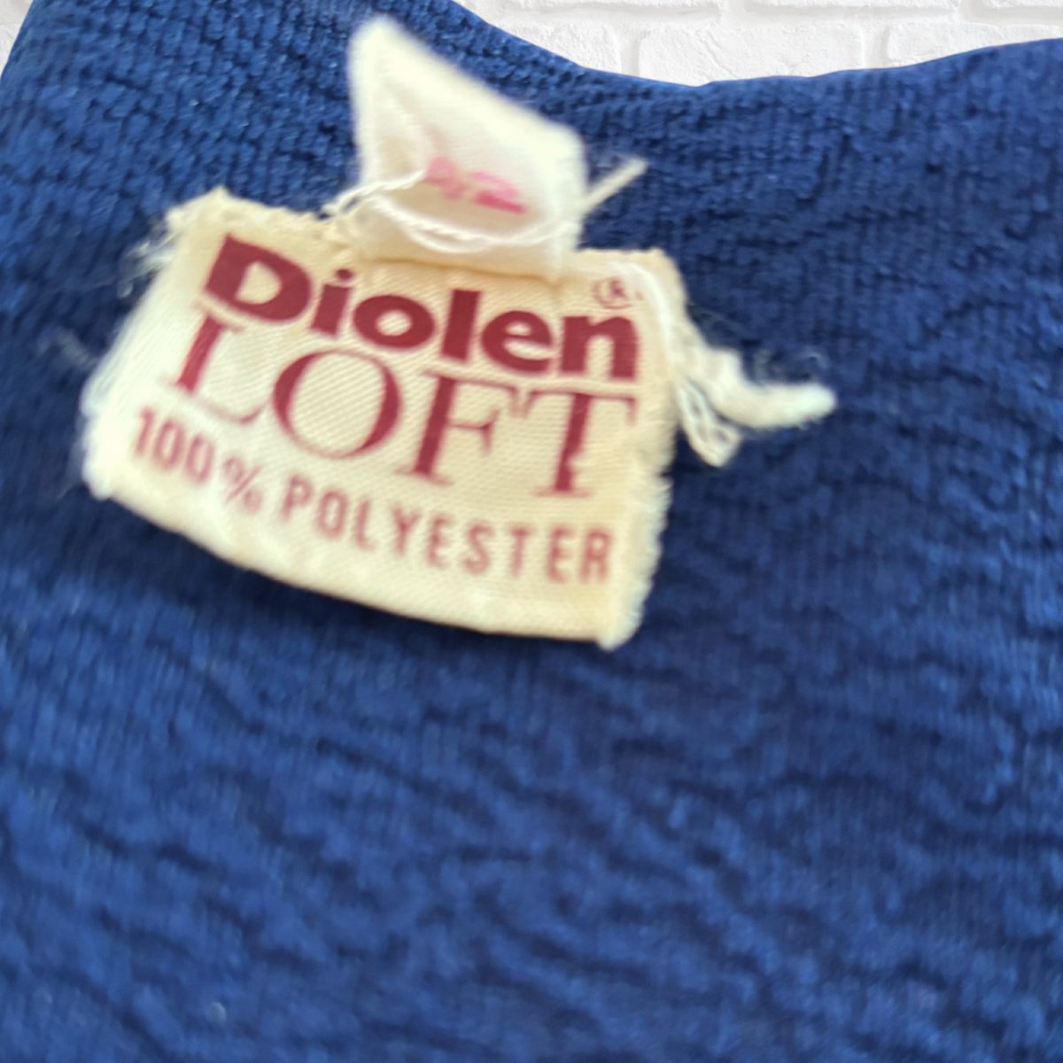 Diolen Loft 100% Polyester label on blue fabric