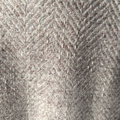 A close-up of a woven jacket fabric texture with a herringbone pattern in taupe, beige, and brown tones.