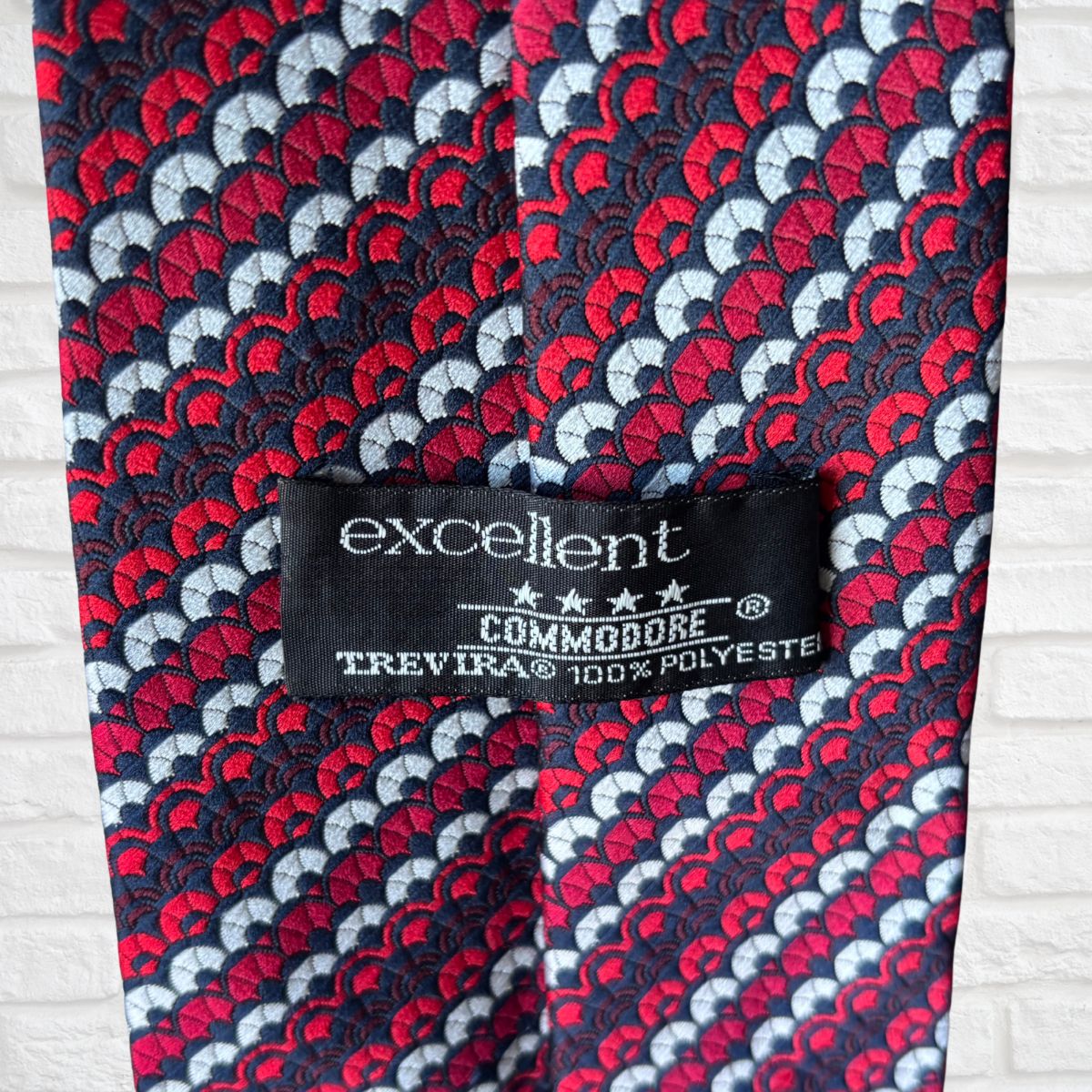 Patterned tie with a visible label on a light wooden surface