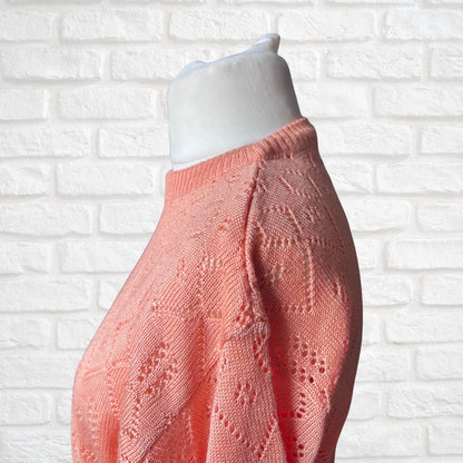 Close up of a silky peach pointelle jumper