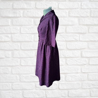 Purple dress on a mannequin against a white brick wall background