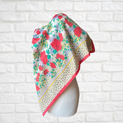 Floral patterned headscarf on a mannequin against a white brick wall background