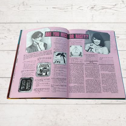 Open book with pink interior pages on a wooden surface