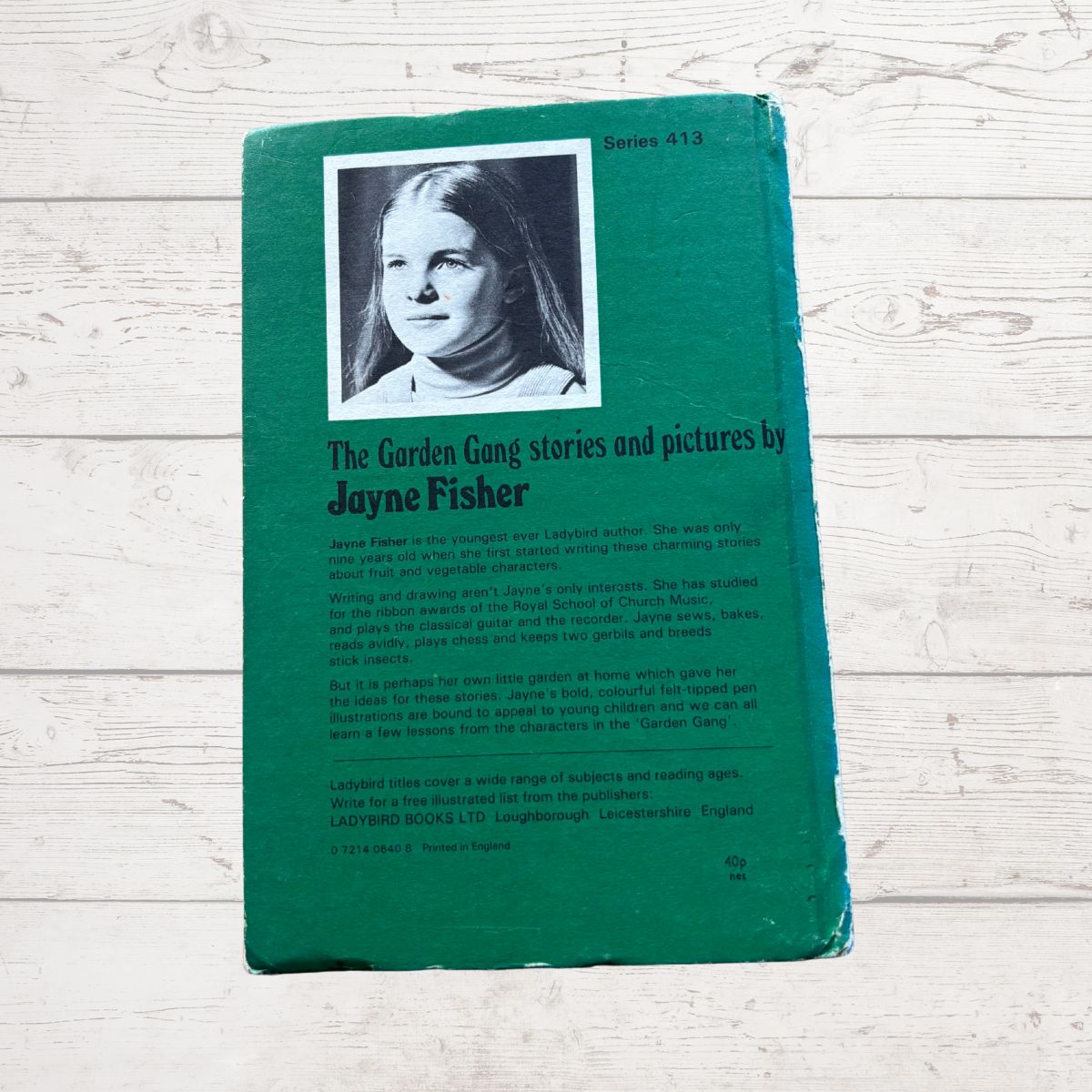 Vintage book titled 'The Garden Gang' with a green cover and black and white photo of a girl on a wooden surface.