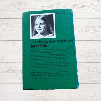 Vintage book titled 'The Garden Gang' with a green cover and black and white photo of a girl on a wooden surface.