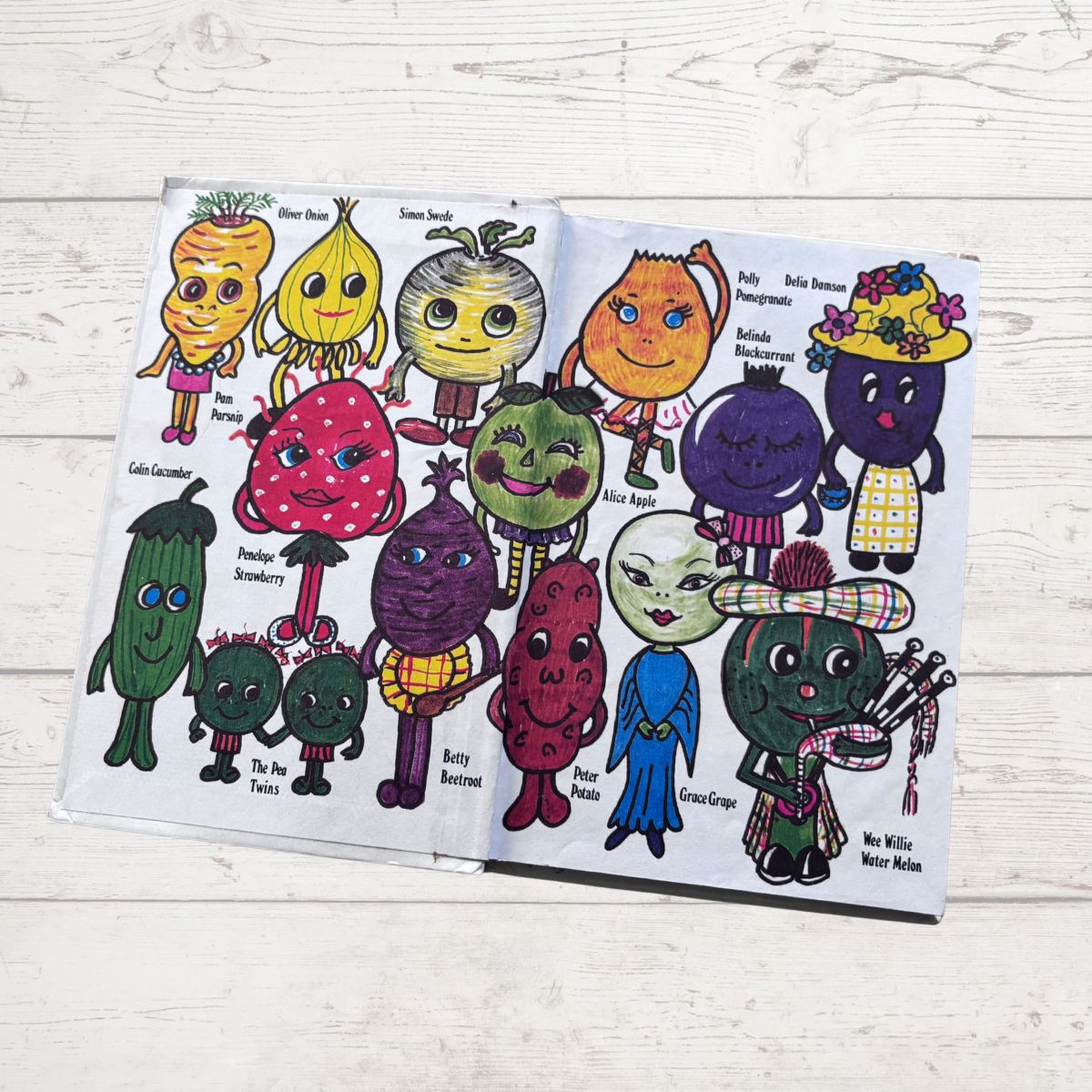  book open to pages with cartoon vegetables on a wooden surface