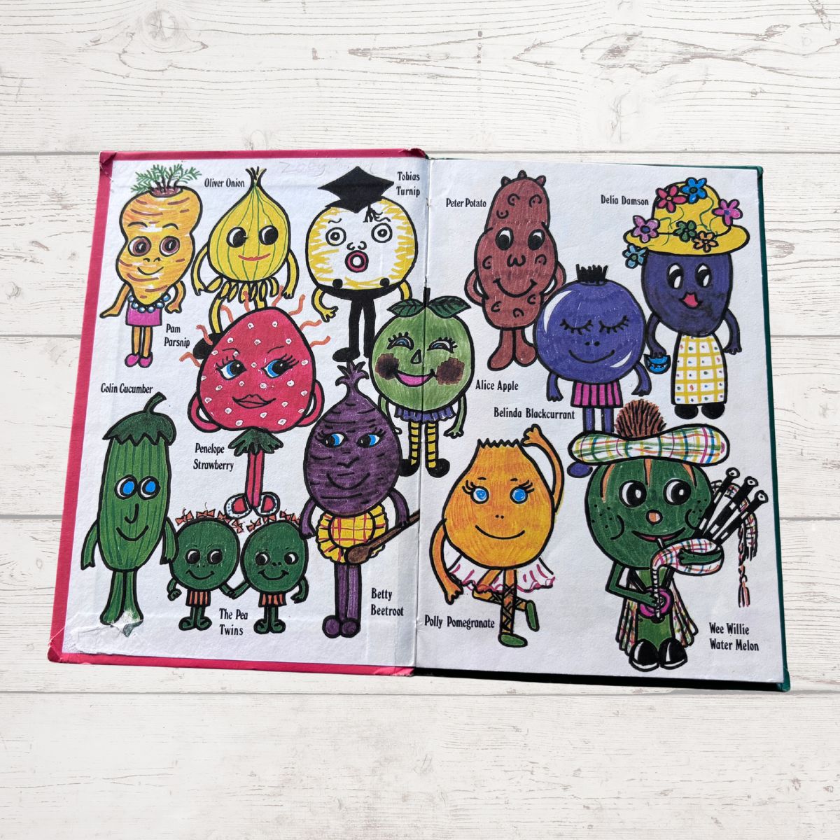 Ladybird book open to pages with cartoon vegetables and fruits on a wooden surface