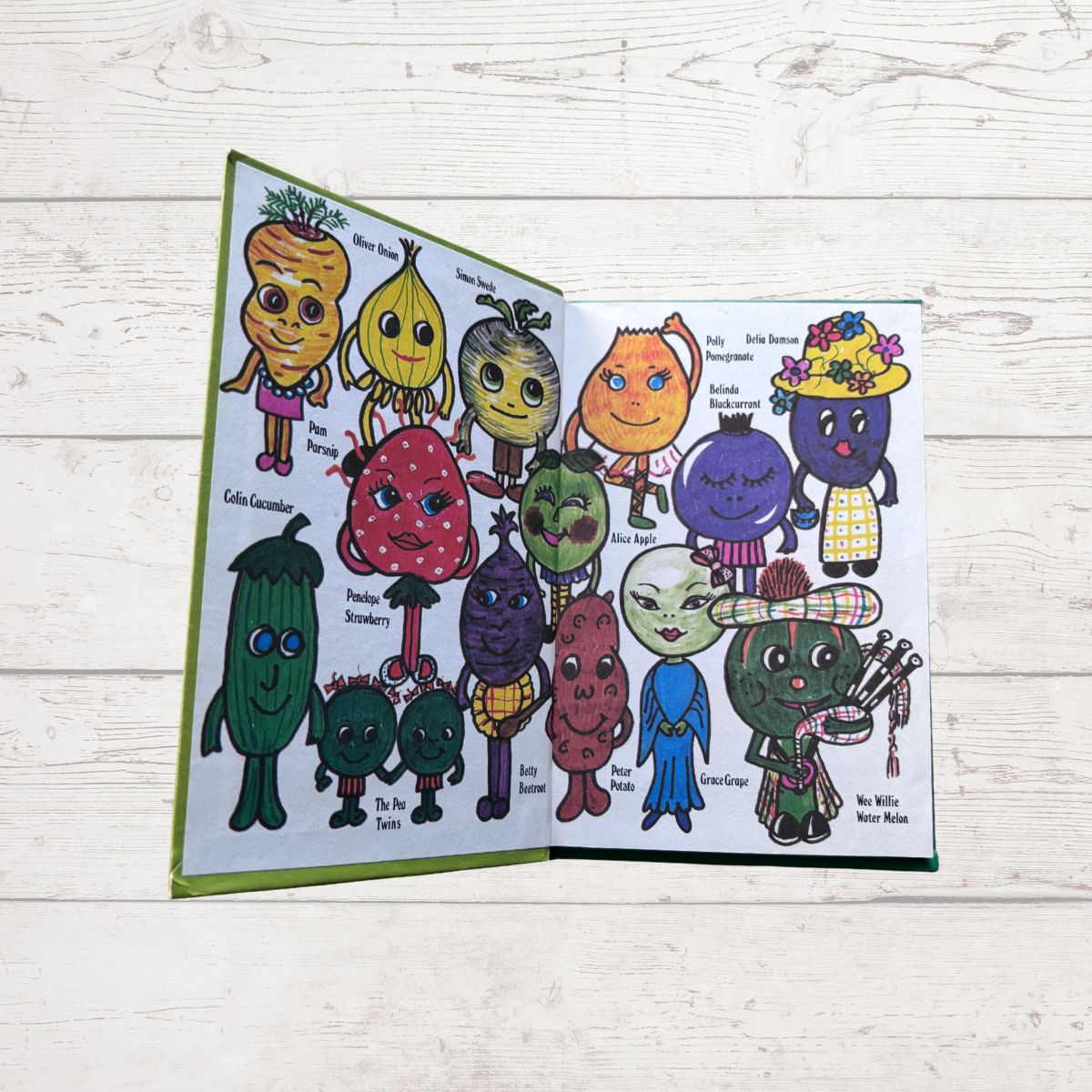 Open book with colorful illustrations of characters on a wooden surface