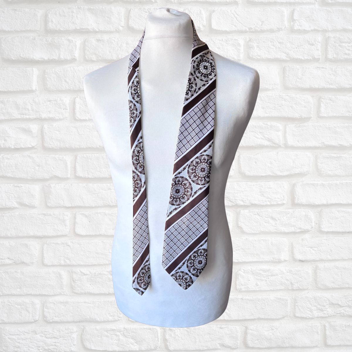 Mannequin wearing a patterned necktie against a white brick wall background