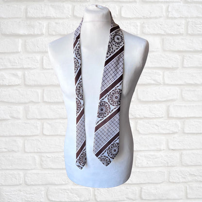 Mannequin wearing a patterned necktie against a white brick wall background