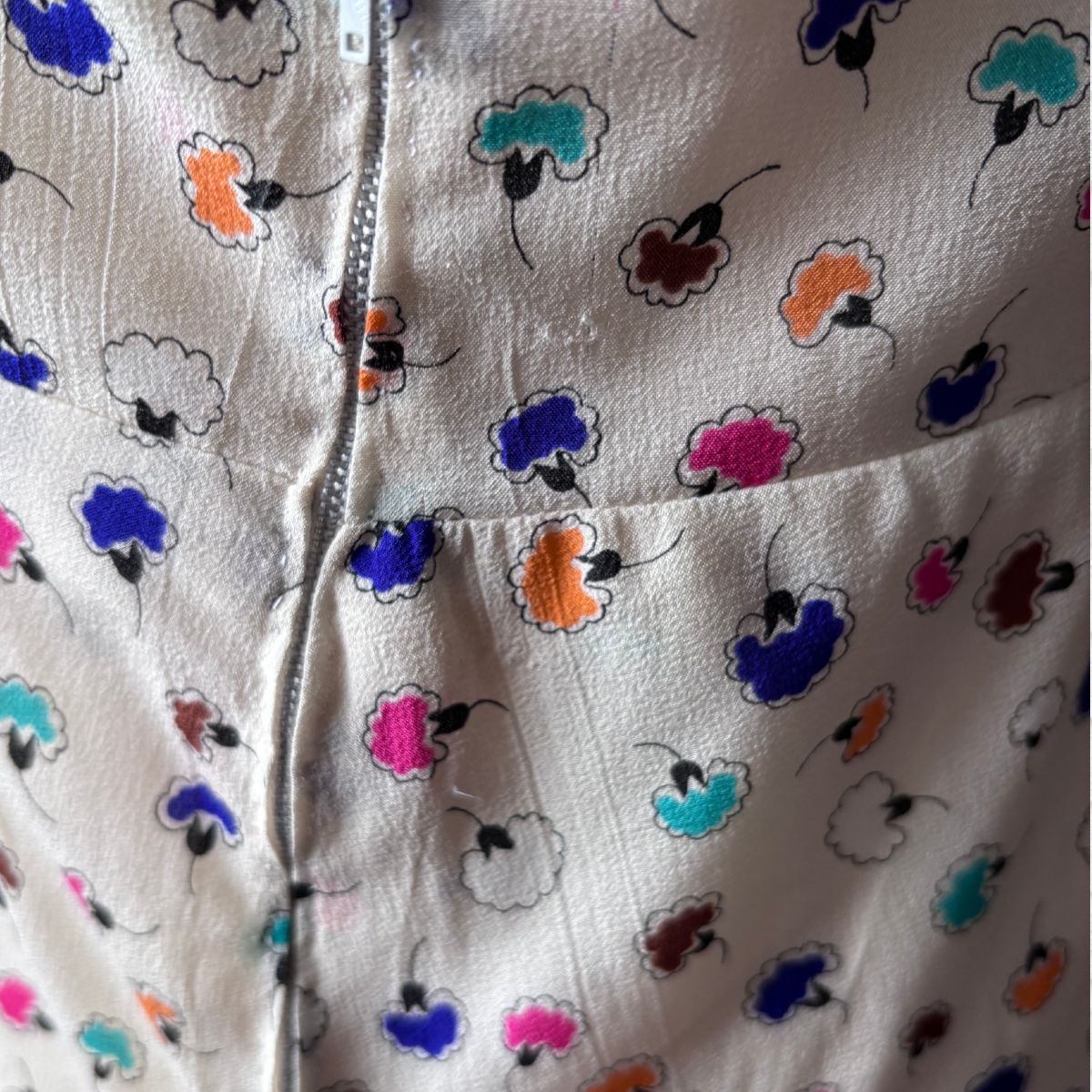 Close-up of a dress fabric with colourful floral patterns on a white background