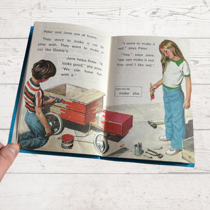 Open book showing illustrations of children playing with a toy car and text.