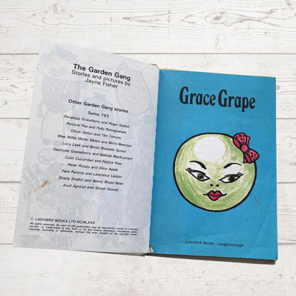 Open book with a blue cover featuring a character illustration on a wooden surface