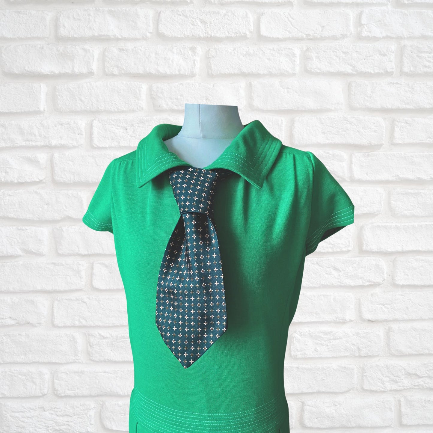 A green, orange and white geometric floral  print vintage 70s tie worn with a green collared 60s dress