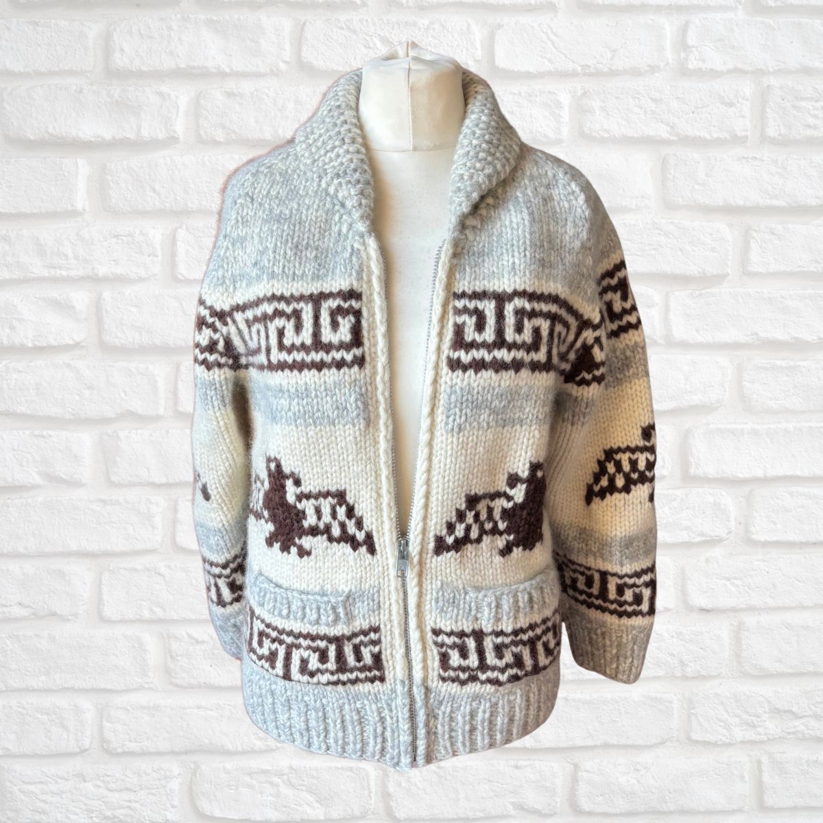 Knitted cardigan with pattern on a mannequin against a white brick wall background