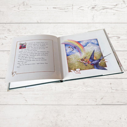 Open book with colorful illustrations on a wooden surface