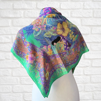 Colorful floral scarf on a mannequin against a white brick wall