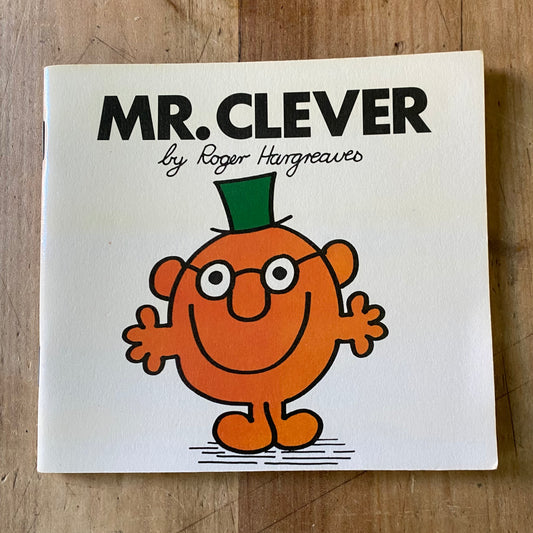 A small white vintage book. Mr Clever by Roger Hargreaves. Cover features of small orange character with glasses and a green top hat 
