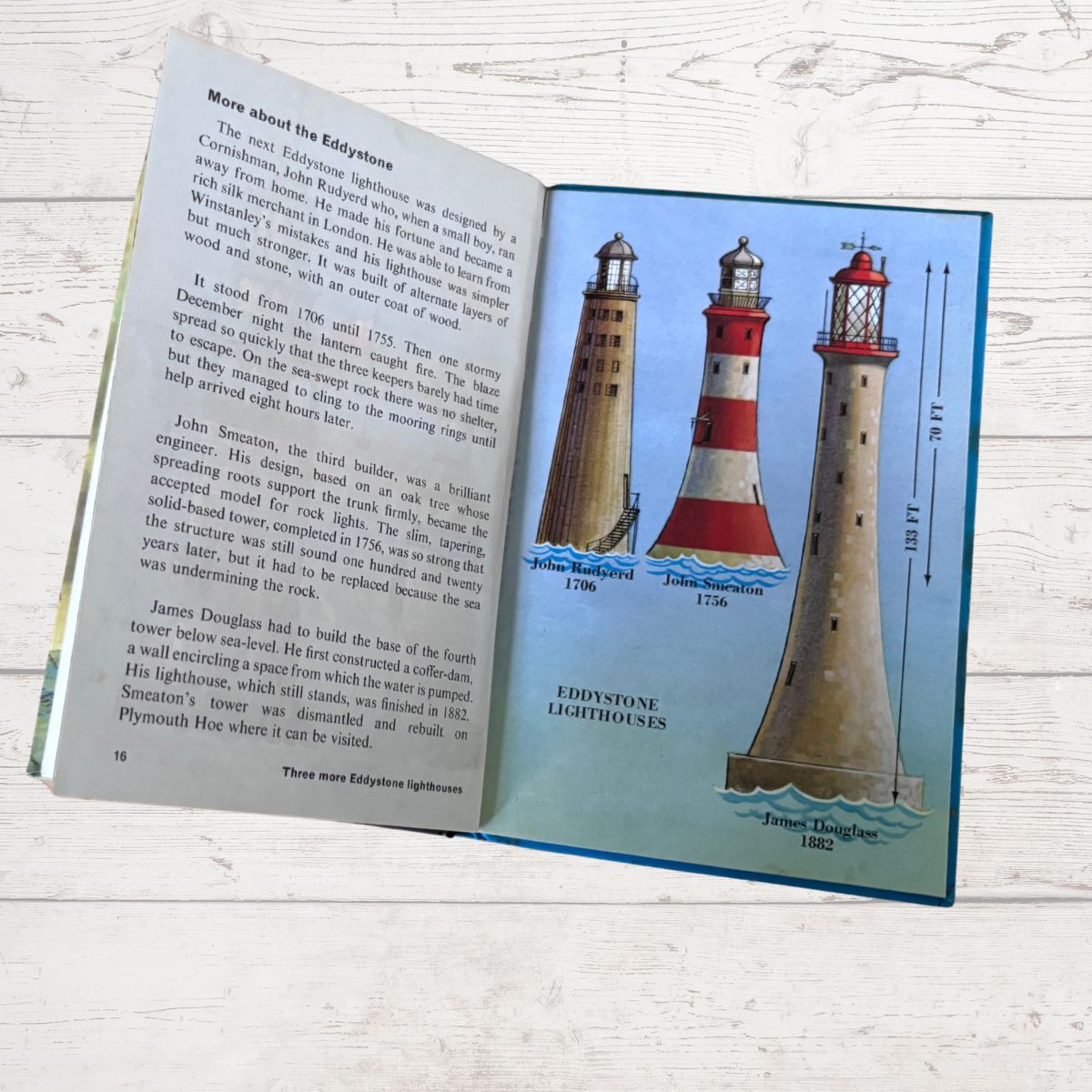 An open children's book titled 'Eddystone Lighthouses' showing printed text on one page and three illustrated lighthouses on the other, photographed on a white wood surface.