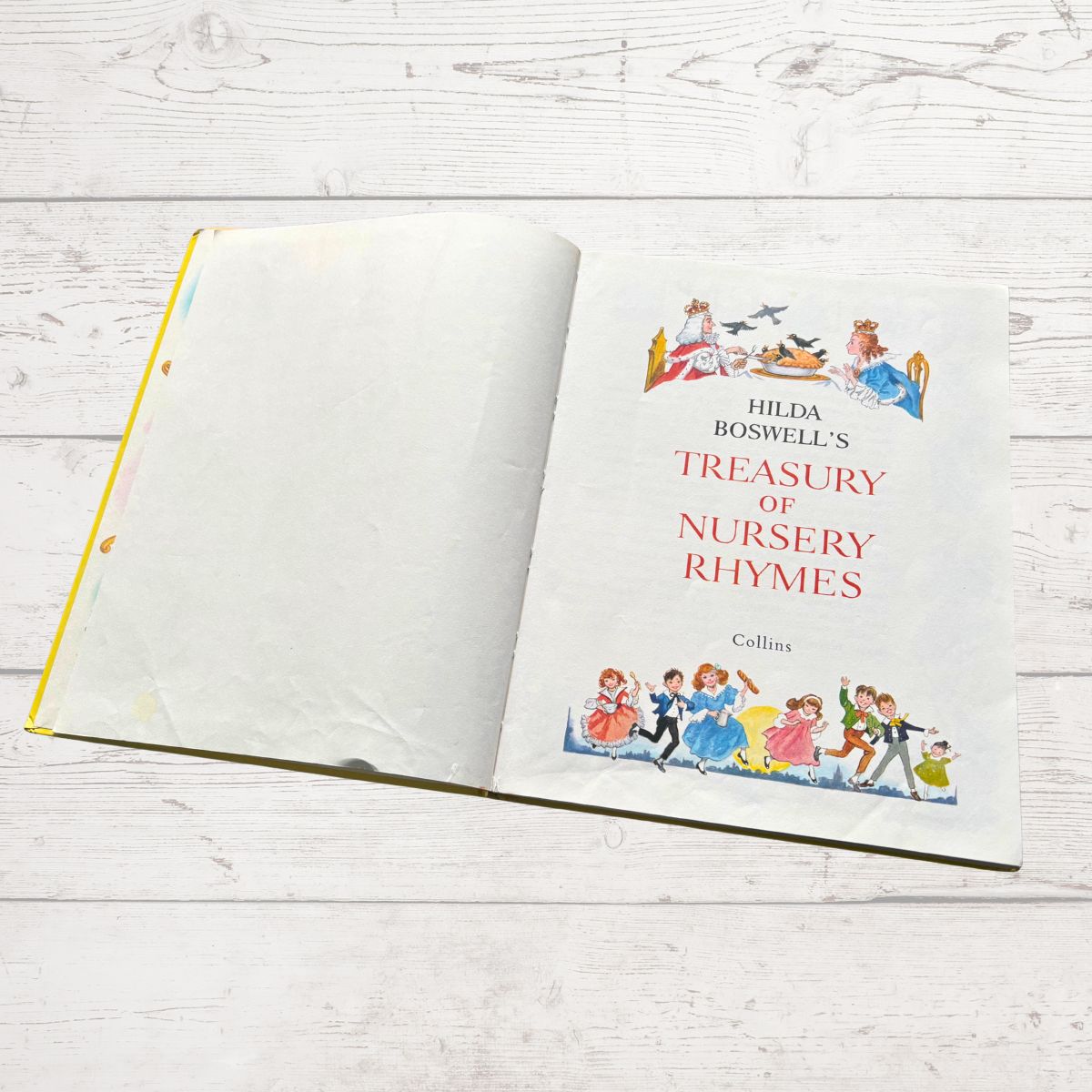 Book titled 'Hilda Boswell's Treasury of Nursery Rhymes' on a wooden surface