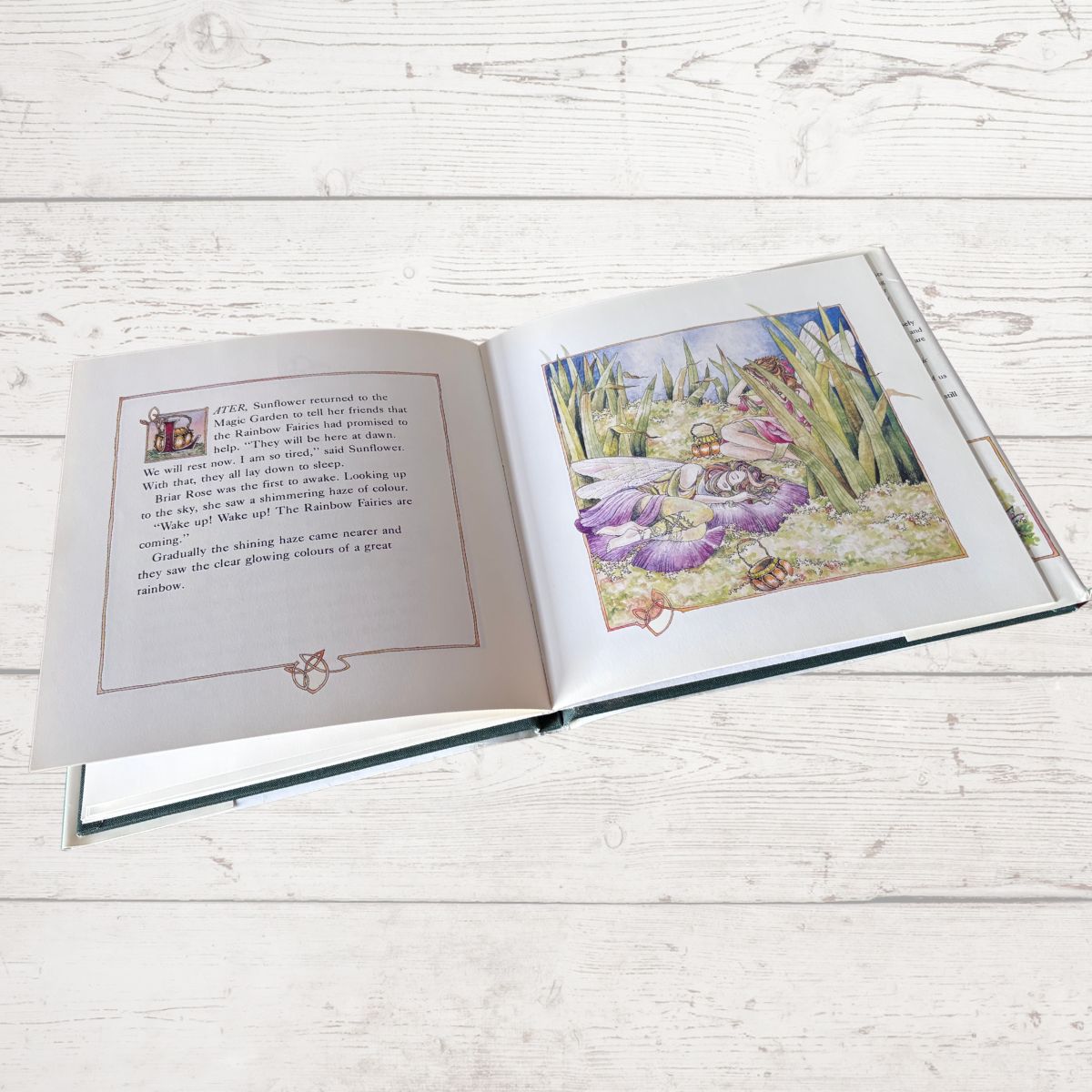 Open book with illustrations on a wooden surface