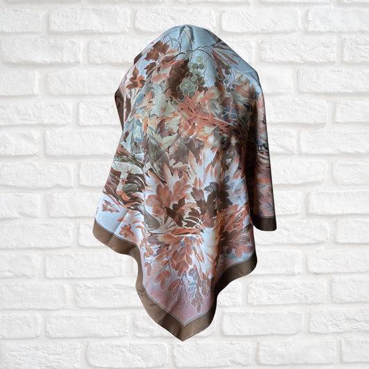 Floral patterned scarf draped over a white brick wall