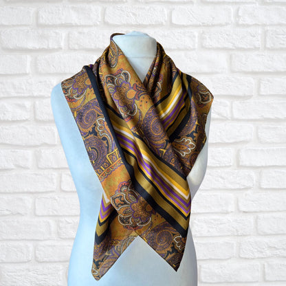 Mannequin wearing a patterned scarf against a white brick wall