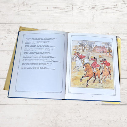 An open children's book lying flat on a light wood surface, showing printed text on the left page and a colorful illustration of horse riders on the right page.