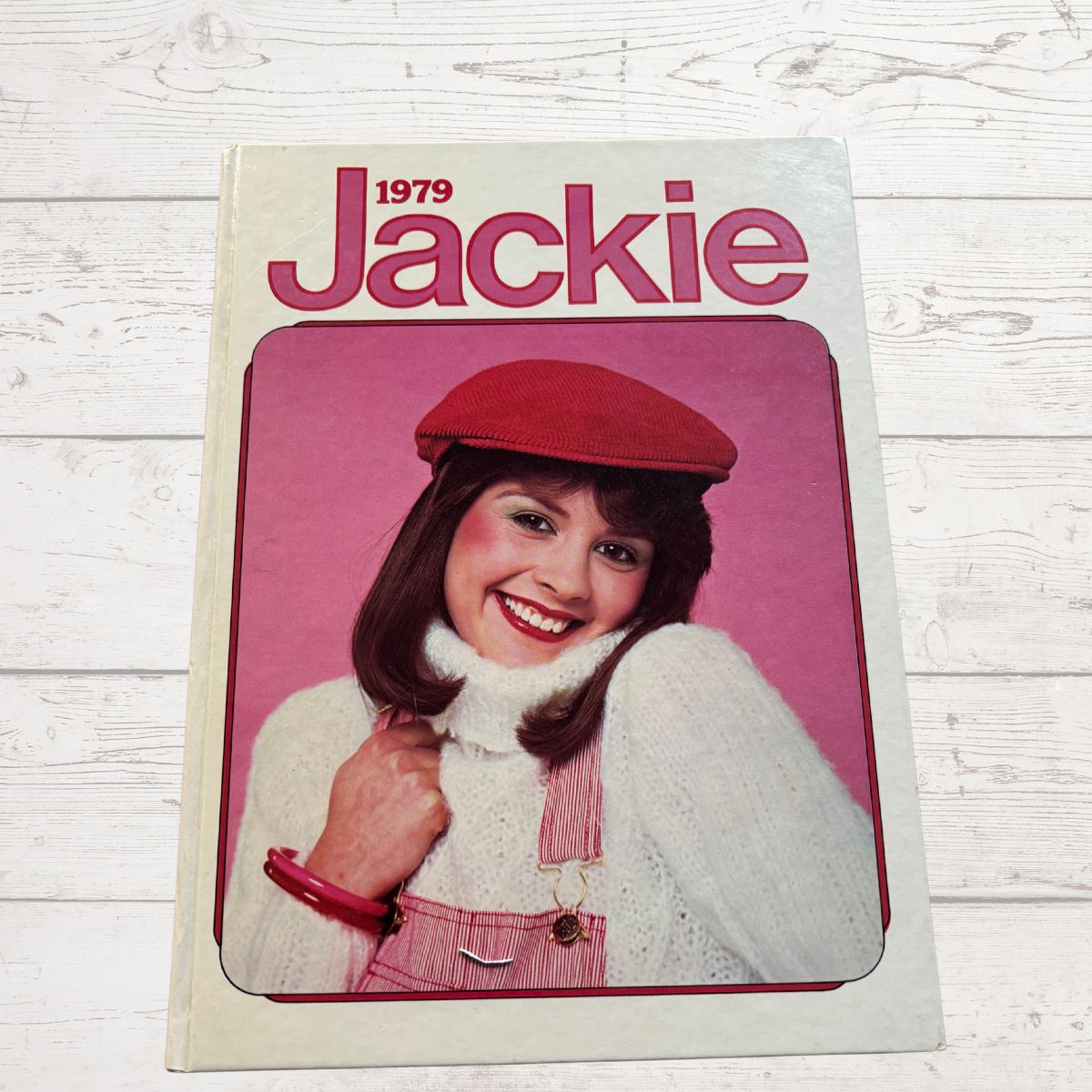 1979 Jackie magazine cover with a model wearing a red beret and white outfit on a light wooden background