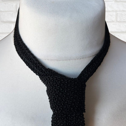 Black knitted tie on a mannequin with a white background