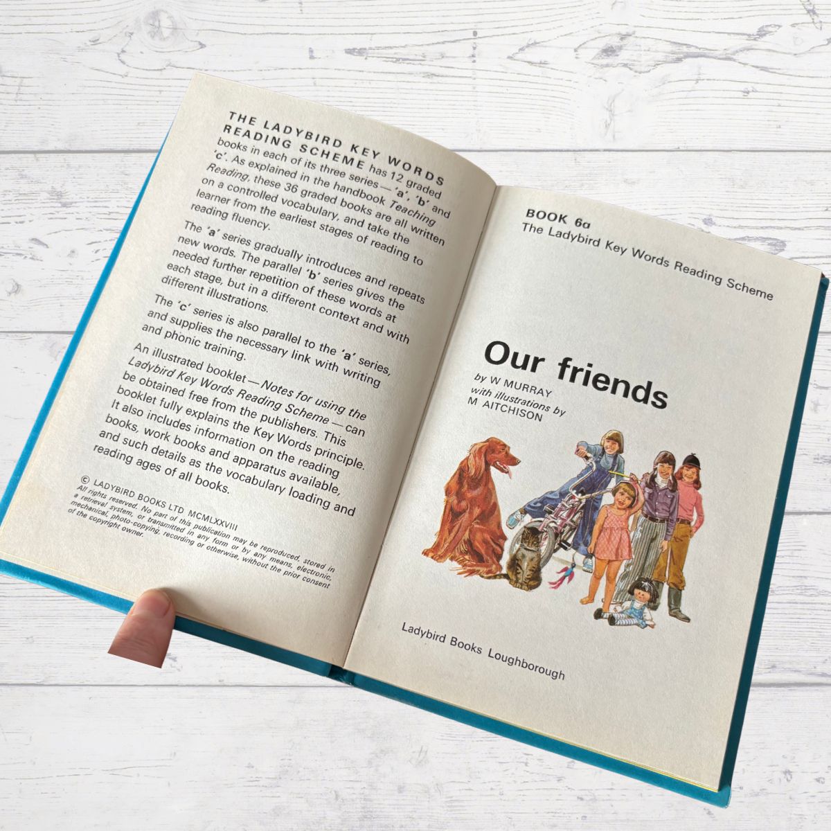 Open book showing a page with text and illustrations on a wooden surface