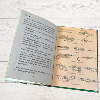 Open book with knot-tying instructions and diagrams on a wooden surface