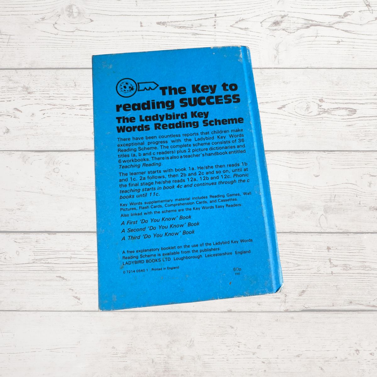 Blue book titled 'The Key to Reading Success' on a wooden surface
