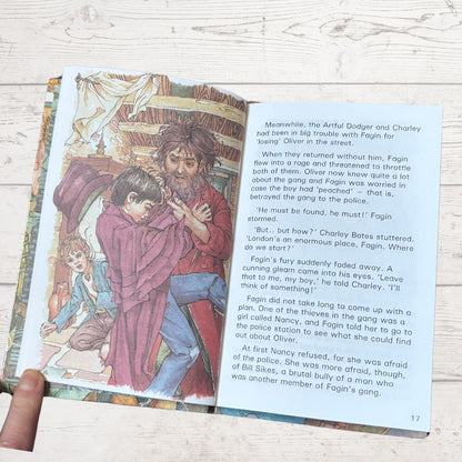 Illustrated book page with a man holding a child and text on a wooden surface